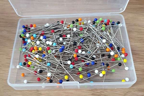 Plusieurs épingles dans un compartiment rectangulaire en plastique 