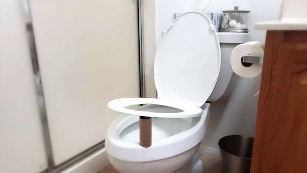 Un rouleau de pq entre les toilettes et la cuvette 