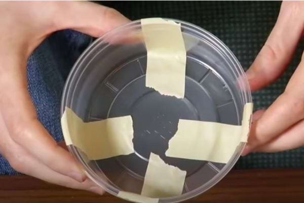 Du scotch sur les quatre coins d'un récipient