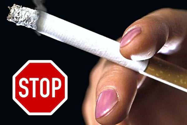 Une femme qui tient entre ses doigts une cigarette allumée