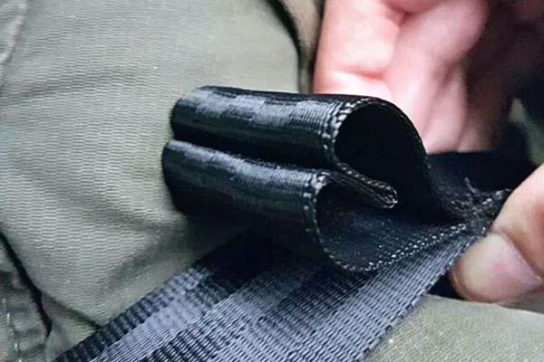 Une personne tenant une ceinture de sécurité de voiture avec une boucle