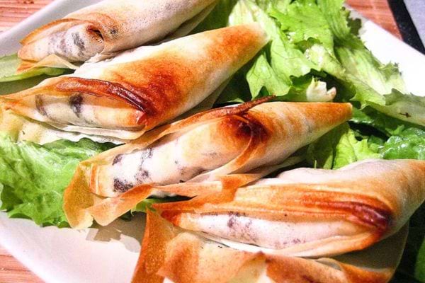 Cinq Bricks boudin noir et pommes sur de la salade dans une assiette 