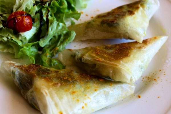 Des Bricks fromage de chèvre et blettes dans une assiette avec de la salade 