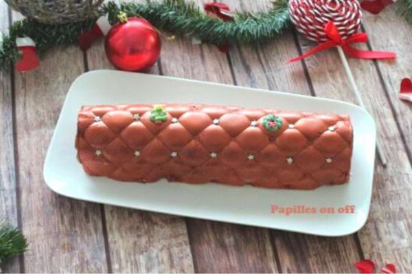Une bûche mousse vanille caramel avec des décorations de Noël sur le côté 