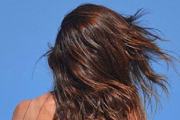 Les cheveux d'une femme qui brille de couleur brun clair