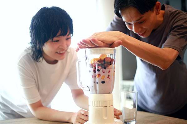 Une homme et une femme asiatique qui font un smoothie 