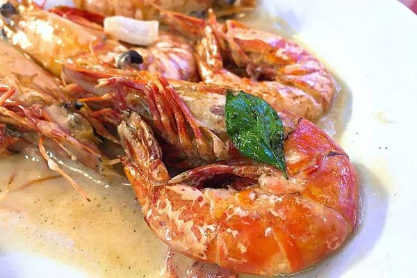 Des crevettes avec de la sauce dans une assiette 