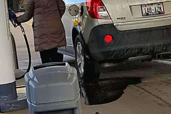 Une femme qui a trop rempli son réservoir d'essence