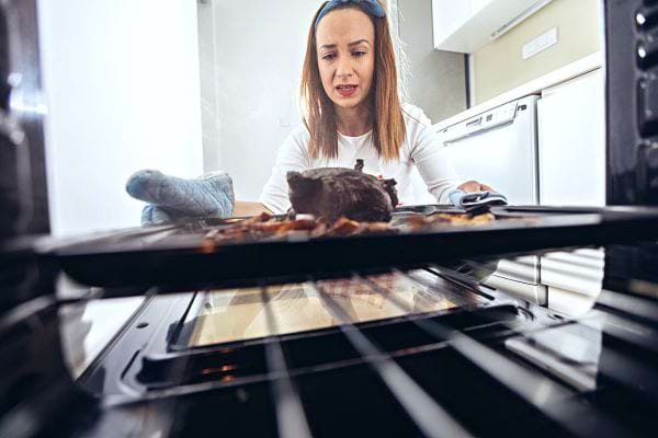 Une femme sortant un plat du four