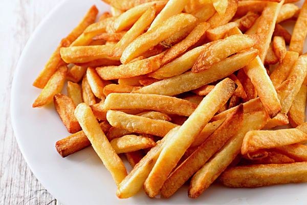 Plusieurs frites dans une assiette blanche