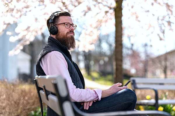 Un homme avec un casque qui est assis sur un banc 