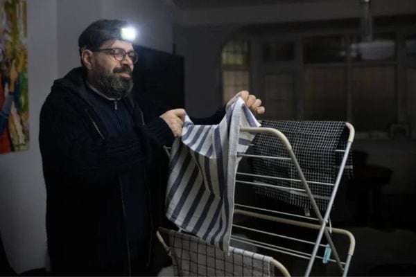 Un homme avec une lampe sur la tête qui étend des linges 