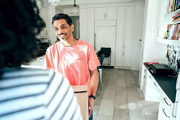 Un homme qui porte un carton 