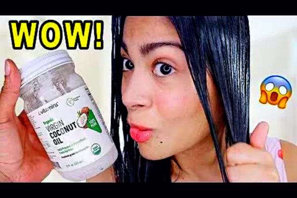 Une femme mettant de l'huile de coco sur ses cheveux 