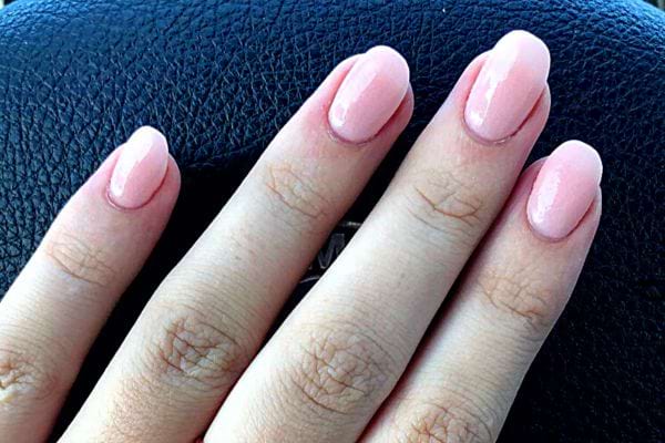 La main d'une personne avec des ongles carrés arrondis