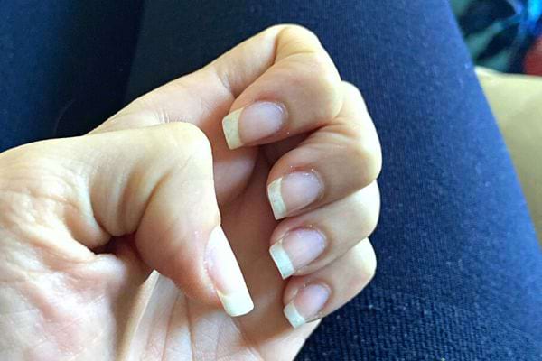 La main d'une personne avec des ongles carrés