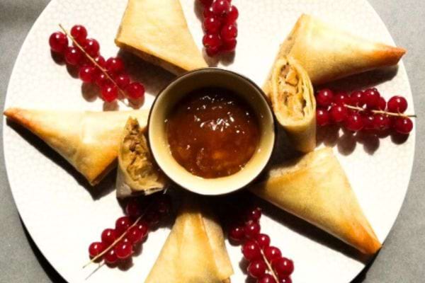 Des samossas remplis de bouchée foie gras et pommes avec des fruits rouges dans l'assiette 