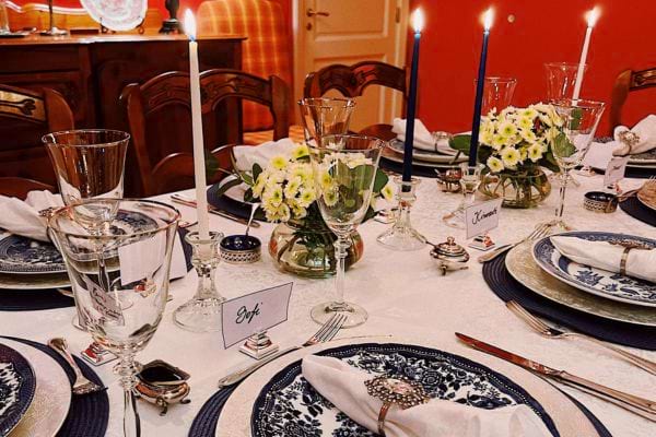 Table de fête raffinée avec vaisselle fine, verres en cristal et bougies.