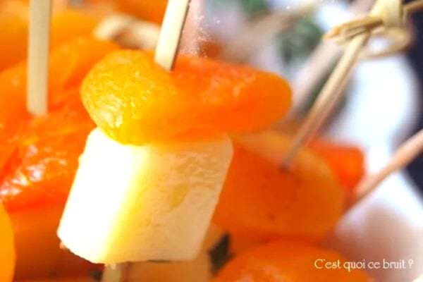 Brochettes d'abricot et fromage sur un fond de fruits.