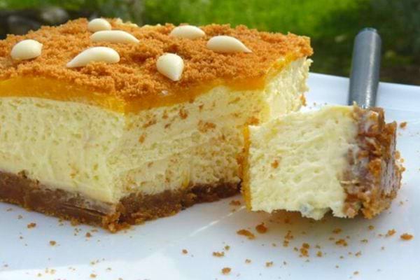 Entremet sans cuisson à la mangue et au chocolat blanc, parsemé de copeaux de chocolat.