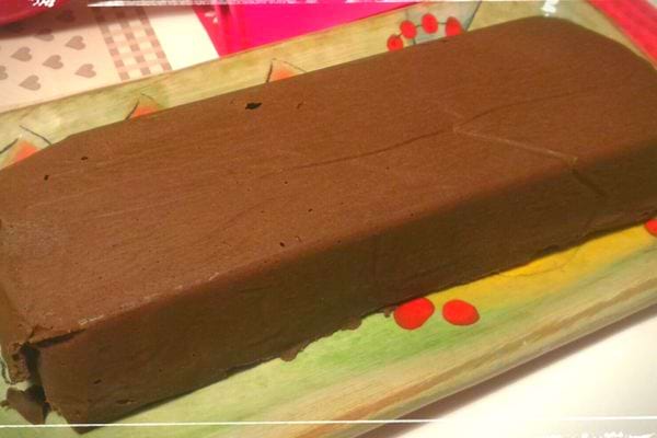 Gâteau au chocolat Thermomix sans cuisson, long et moelleux, posé sur un plateau coloré.