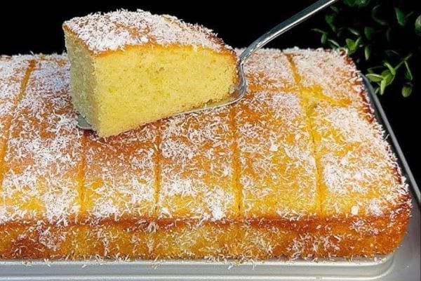 Gâteau saupoudré de noix de coco, part levée.