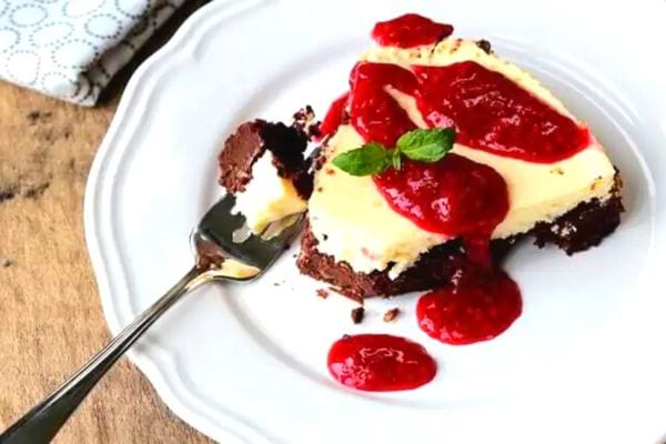 Gâteau au fromage et chocolat sans cuisson, avec coulis de framboises et feuille de menthe.