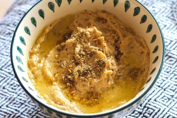 Du Houmous aux oignons caramélisés dans une coupelle blanche pour l'apéro