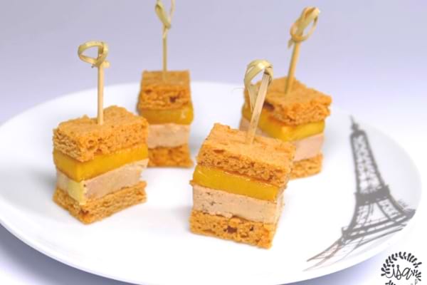 Canapés au pain d'épices au foie gras mangue sur assiette blanche
