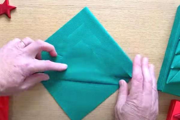 La serviette verte est retournée pour créer la forme de sapin.