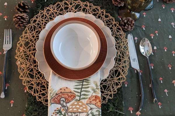 Table champêtre avec assiette et nappe à motif nature.
