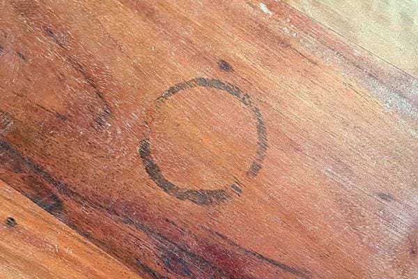 Une marque ronde de tache de café sur une table en bois.