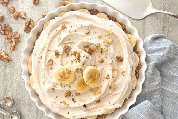 Tarte à la banane et à la noix de coco sans cuisson, saupoudrée de noix concassées.