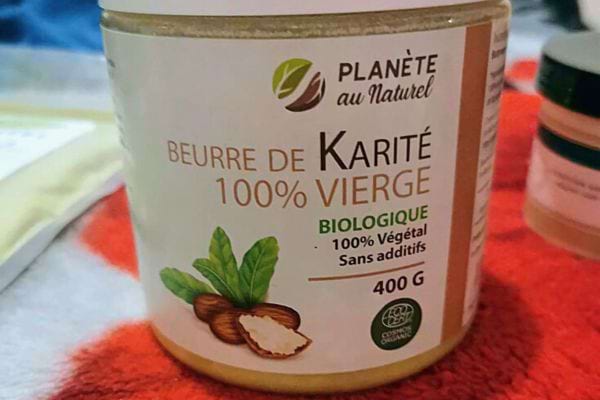 Pot de beurre de karité biologique sur une surface texturée.