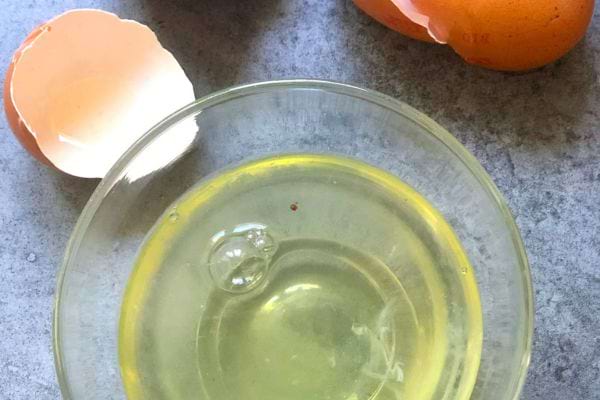 Frisches Eiweiß vom Eigelb getrennt und in einer kleinen Glasschüssel ruhen lassen.