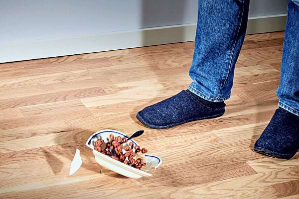 Un bol cassé sur le sol avec des céréales éparpillées, indiquant une malchance soudaine.