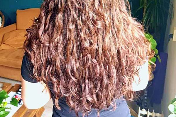 Résultat final montrant de belles boucles brunes bien définies après un traitement à l'huile.