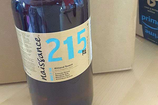 Bouteille d'huile d'amande douce avec une étiquette bleue.