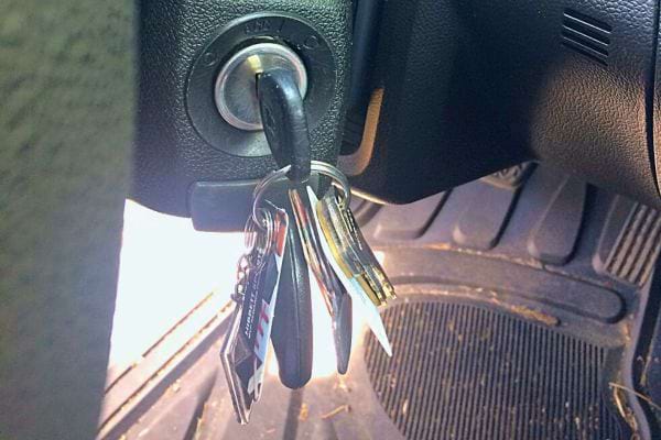 Clé dans le contact d'une voiture, éclairée par la lumière du soleil.