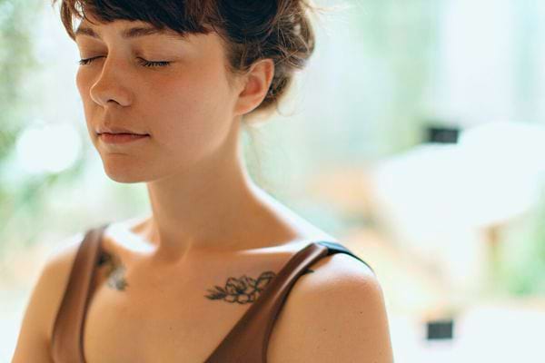 Une femme avec les yeux fermés, appréciant un moment de calme.