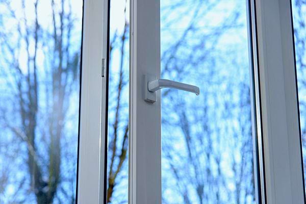 Poignée fermée, paysage hivernal flou en fond.