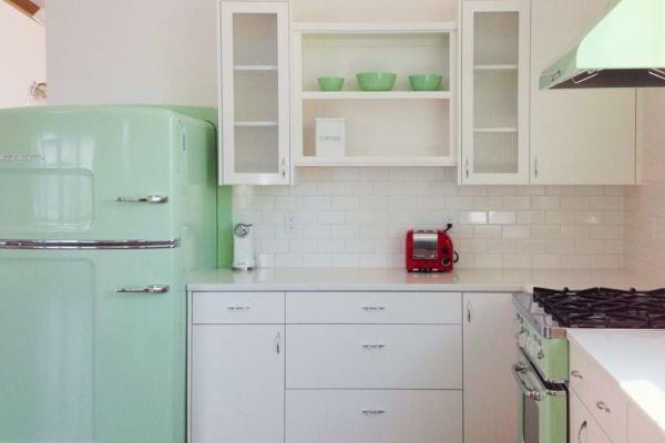 Frigo rétro vert assorti à une décoration vintage, créant une ambiance cohérente avec le style de la cuisine.