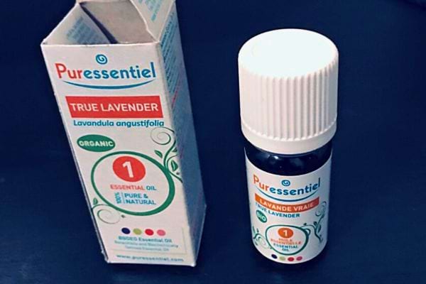 Un flacon d'huile essentielle de lavande à côté de sa boîte.