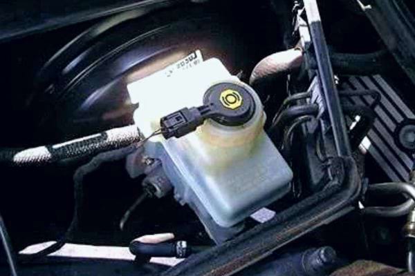 Durchsichtiger Bremsflüssigkeitsbehälter im Motorraum, möglicherweise sauber oder kürzlich gefüllt.