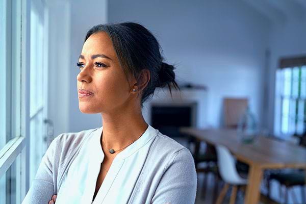Une femme réfléchit près d'une fenêtre, considérant les leçons de vie