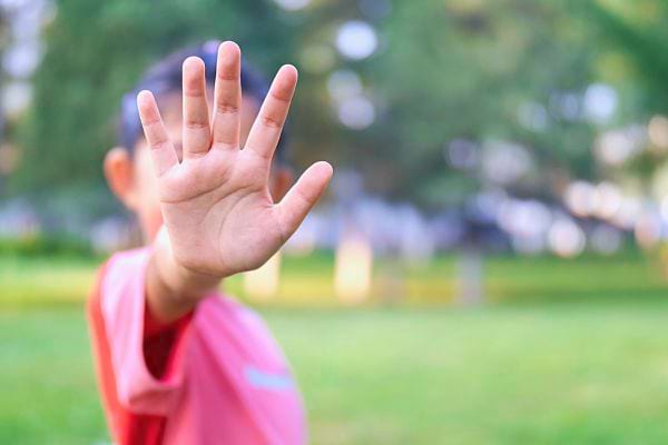 La main tendue d'une enfant, représentant les limites personnelles et le respect de soi.