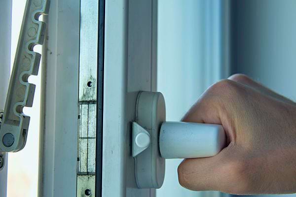 Main sur poignée de fenêtre avec bord givré