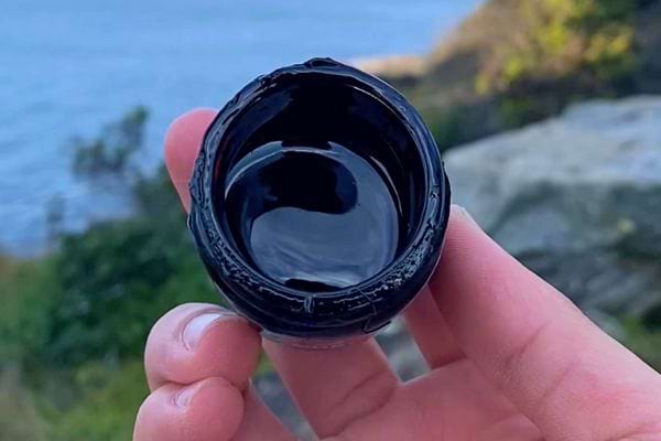 Vue de dessus d'un pot de Shilajit ouvert, montrant la résine noire.