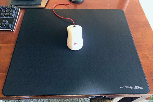 Une souris blanche d'ordinateur sur un tapis noir 