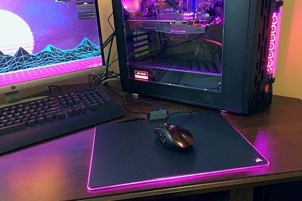 Un tapis de souris sur le bureau avec pleins de couleurs sur l'ordinateur et la centrale 